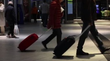 Naples, Italy - January 3, 2023: Inside the central Naples railway station, travelers move around walking with suitcases in the direction of the departure platform.