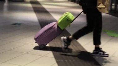 Naples, Italy - January 3, 2023: Inside the central Naples railway station, travelers move around walking with suitcases in the direction of the departure platform.