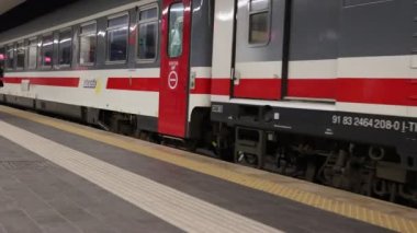 Naples, Italy - February 15, 2023: The train arrives and stops at the platform of the central station and the passengers get off the carriages and walk towards the exit.