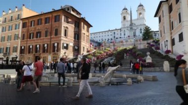 Roma, İtalya - 26 Nisan 2023: Barcaccia çeşmeli Piazza di Spagna, ön planda ve arka planda renkli çiçeklerle kurulmuş muhteşem İspanyol Merdivenleri.