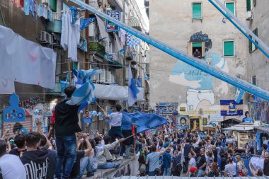 Napoli, İtalya - 5 Mayıs 2023: Napoli futbol takımının taraftarları İtalya 'nın sokakta kazandığı zaferi kutluyorlar. Öforik insanlar Maradona duvar resminin önündeki İspanyol konutlarına akın ediyor..