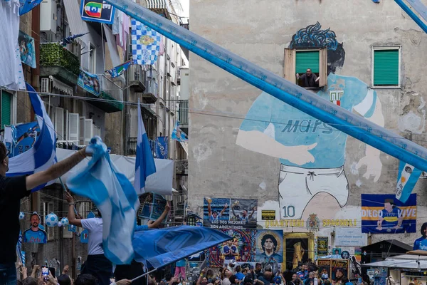 stock image Naples, Italy - May 5, 2023: Fans of the Napoli football team celebrate the victory of the Italian championship in the street. Euphoric people flock to the Spanish quarters in front of the Maradona mural.