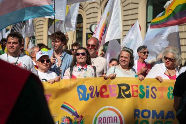 Roma, İtalya - 10 Haziran 2023: Büyük Gay Gururu LGBTQ + gururunu göstermek için başkentin sokaklarında geçit töreni. Fotoğrafta bazı göstericiler tören sırasında bir pankart sergiliyorlar.. 
