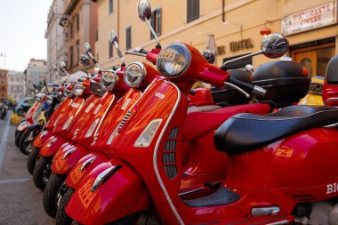 Roma, İtalya - 17 Haziran 2023: Kırmızı renkli Vespa scooterlar grubu park etti. Kasabada scooter kiralama.