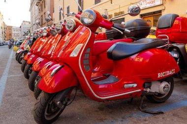 Roma, İtalya - 17 Haziran 2023: Kırmızı renkli Vespa scooterlar grubu park etti. Kasabada scooter kiralama.