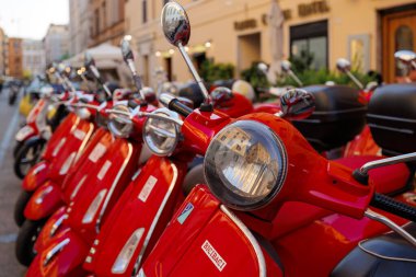 Roma, İtalya - 17 Haziran 2023: Kırmızı renkli Vespa scooterlar grubu park etti. Kasabada scooter kiralama.