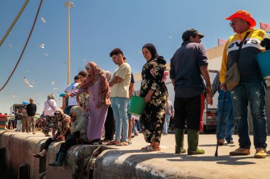 Essaouira, Fas - 2 Ağustos 2023 Limanın rıhtımında insanlar balıkların boşaltılmasını bekliyor ki satın alabilsinler..