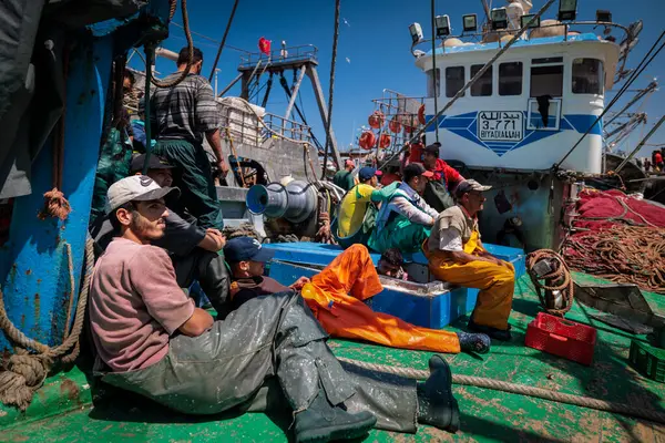 stock image Essaouira, Morocco - August 2, 2023: A fishing vessel anchored at the port quay with her crew, her men resting after the night spent at sea fishing in the waters of the Atlantic Ocean.