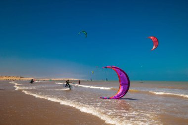 Essaouira, Fas - 3 Ağustos 2023: uçurtma uçuran çok sayıda okyanus plajı. Burası bu yelkencilik sporunun aşıkları ile ünlüdür. Uçurtmayı kolayca kaldırabilen güçlü rüzgârlarıyla..