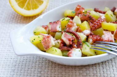 Ahtapot küçük parçalar halinde kesilmiş ve patates ve maydanoz ile hazırlanmış. Lezzetli, yemek hazır. İtalyan mutfağının geleneksel tarifi.