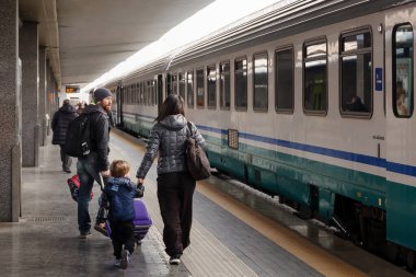 Naples, İtalya - 13 Mart 2017: In Napoli Merkez İstasyonu'na bir ailede anne, baba ve küçük oğlu, yürür Bagaj ile izlemek için nereye park ettiğini numaralı treni.