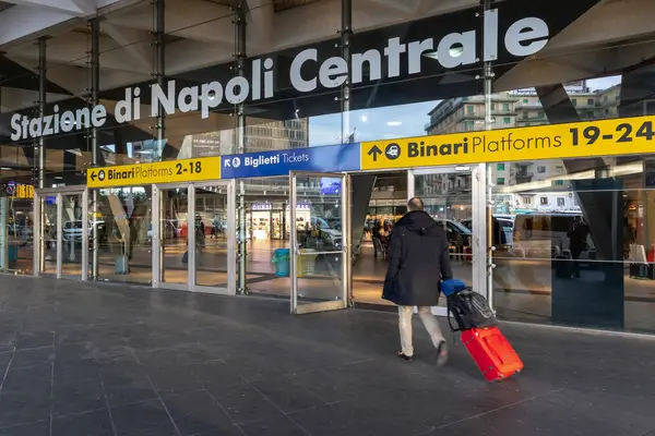 Naples, Italy - February 12, 2020: a main entrance of Garibaldi central railway station. Tourists with bags and suitcases rush to access the train tracks.