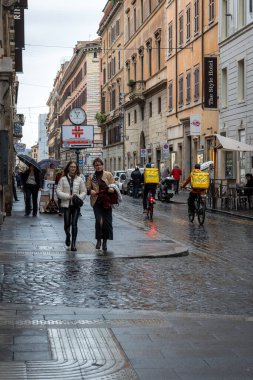 Roma, İtalya - 7 Kasım 2023: Bisikletli iki çocuk şehrin tarihi merkezinde eve teslim edilecek yiyecekleri taşıyor.