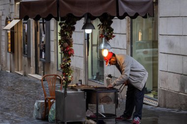 Roma, İtalya - 7 Kasım 2023: Şehrin tarihi merkezinde tezgahı olan kavrulmuş kestane satıcısı.