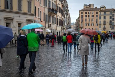 Roma, İtalya - 7 Kasım 2023: Bir sonbahar günü insanlar şehrin tarihi merkezinde yürürler kendilerini açık şemsiyelerle yağmurdan korurlar..