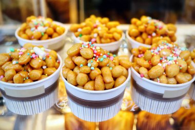 Struffoli dolu bardaklar, yağda kızartılmış ve sıcak bala sarılmış küçük hamur toplarından oluşan tipik Napoli hamur tatlısı. Renkli süslemelerle süslenmiş..