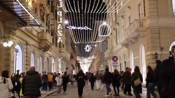 ローマ イタリア 12月 2023 クリスマスライトで飾られ クリスマス前に最後のギフトを購入する人々と混雑デルコルソ経由 — ストック動画