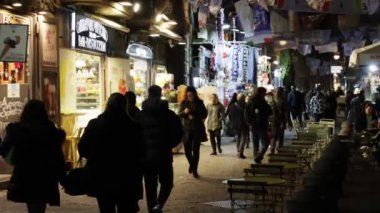 Napoli, İtalya - 21 Aralık 2023: Şehrin tarihi merkezinde, renkli ışıklarla süslenmiş, vatandaşlar akşam yürüyüşü.