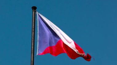 Çek Cumhuriyeti bayrağı mavi gökyüzünün arka planında dalgalanıyor. Çek bayrağının renkleri