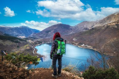 Yolda duran yürüyüşçü, Scanno Gölü 'nün bir kalbe benzeyen manzarasına hayran. İtalya 'da Abruzzo' nun manzarası.