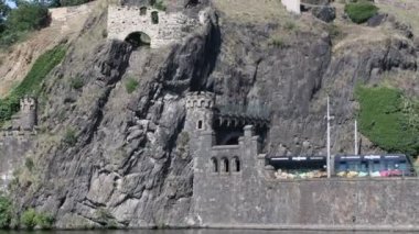 Prag, Çek Cumhuriyeti - 7 Temmuz 2023: Prag şehrinden geçen Vltava Nehri üzerinde seyir. Eski bir şato şeklinde girişi olan kayanın içine küçük bir tünel kazılmış..