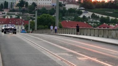 Prag, Çek Cumhuriyeti - 9 Temmuz 2023: Üstü açık klasik bir araba Çek Cumhuriyeti 'nin Prag kentindeki köprüden geçer. Avrupa 'da şehir hayatı.