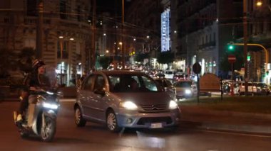 Napoli, İtalya - 9 Kasım 2024: Arabalar ve motosikletler akşam trafiğinde yavaşça geçer. Şehir merkezinin sokaklarında trafik vardı..
