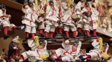 Napoli, İtalya - 12 Aralık 2024: San Gregorio Armeno 'nun tezgahlarında Pulcinella karakterini tasvir eden el yapımı heykelcikler, Noel hediyelerinin ünlü caddesi..