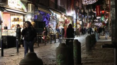Napoli, İtalya - 12 Aralık 2024: Via dei Tribunali, şehrin tarihi merkezinde, Noel tatilleri boyunca turistik bir yer olan gece aydınlandı.