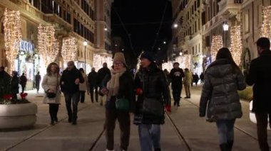 Roma, İtalya - 25 Aralık 2024: İnsanlar Vatikan yakınlarındaki Via Ottaviano boyunca Noel ışıkları ve süslemeleri ile süslenmiş şekilde geziyorlar. Roma şehrinde Noel atmosferi.