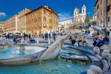 Roma, İtalya - 26 Aralık 2024: Çok ünlü Piazza di Spagna 'da günlük yaşamın manzarası garip bir şekilde kalabalık değil. Ön planda, Barcaccia çeşmesi, ve arka planda İspanyol Merdivenleri, şehrin tarihi merkezinde.