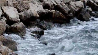 Denizin dalgaları kayalık resiflerde köpüklü su sıçratır. Fırtınalı deniz, dalgalı deniz