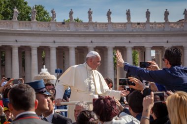 Roma, İtalya - 30 Nisan 2016: Papa Bergoglio Vatikan 'daki Aziz Peter Meydanı' nda beyaz bir cübbe içinde gülerek inananları selamlıyor. Arka planda Aziz Peter Bazilikası 'nın sütunları var..