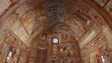 Caporciano (AQ), İtalya - 8 Mart 2025: San Pellegrino Oratory of San Pellegrino 'nun ogival varil kasası ile tek nav iç mimarisi, 1263 yılında Bominaco köyünde inşa edildi. Duvarlar, dini temalı duvar fresklerinin olağanüstü bir döngüsüyle kaplı..
