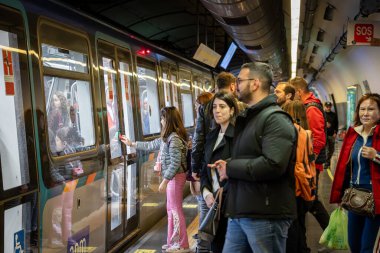 Napoli, İtalya - 18 Nisan 2025: Kentin metro hattı 1 'deki Garibaldi istasyonundaki vagonlara binmeden önce platforma binen yolcular.
