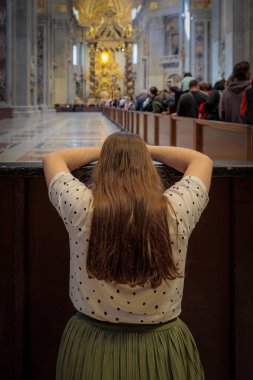 Vatikan Şehri, Vatikan - 25 Nisan 2025 St. Peter Bazilikası 'nda genç bir kadın dua ediyor..