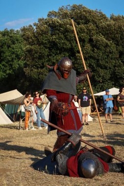 Ladispoli (RM), İtalya - 28 Haziran 2025: Drakkar Viking Festivali, Viking tarihinin yeniden canlandırması. Zırh giyen iki Viking savaşçısı sahte bir savaşta karşı karşıya, İskandinav kültüründe. Tarihi Canlandırma.