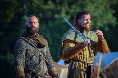 Ladispoli (RM), İtalya - 28 Haziran 2025: Drakkar Viking Festivali, Viking tarihinin yeniden canlandırması. Tipik bir Viking savaşçısı İskandinav kültürü tarzında giysi giyiyor. Tarihi Canlandırma