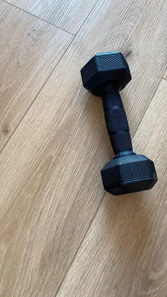 Ahşap bir zeminde oturan bir çift dambıl..