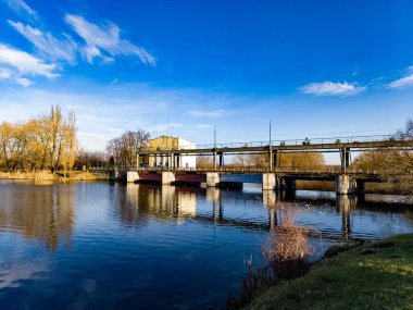 Arka planda bir bina olan bir su kütlesinin üzerindeki köprü..
