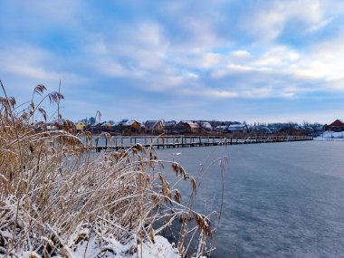 Arkasında köprü olan donmuş bir göl manzarası..