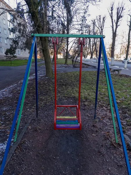 Parkın ortasında renkli bir salıncak.