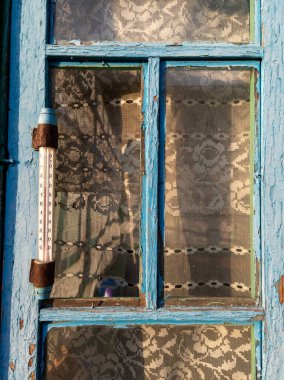 Üzerinde termometre olan mavi bir pencere..