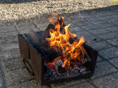Tuğla bir verandada alevler içinde yanan bir ateş çukuru..