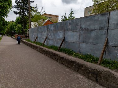 Kaldırımda yürüyen bir adam beton duvarın yanında..