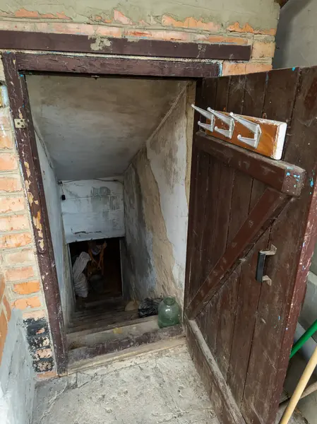 Tahta kapılı ve tuğladan duvarı olan küçük bir odaya açılan bir kapı..