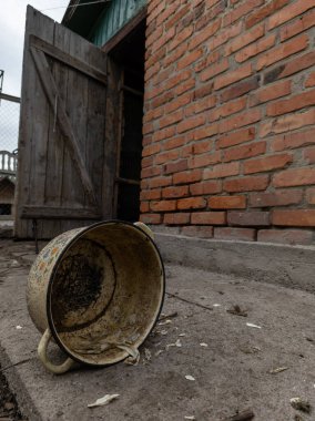 Tuğla binanın önünde duran kirli bir kova..