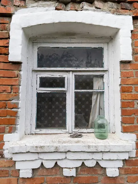 Pencere pervazında duran yeşil vazolu bir pencere..