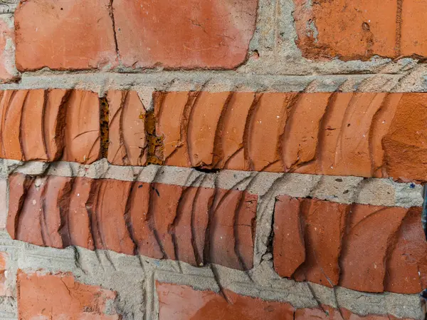 İçinde çatlak olan tuğla bir duvar..