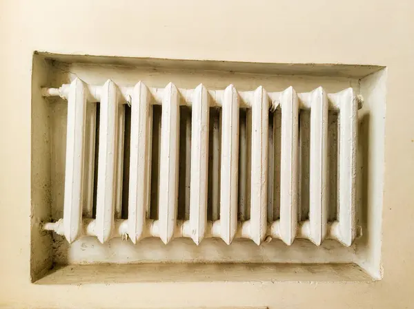 Duvarın köşesinde beyaz bir radyatör..